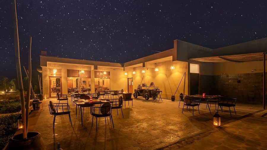 An image of a Rosettes open air restaurant  featuring several sets of tables and chairs and it also has indoor seating spaces - Kurja Jawai
