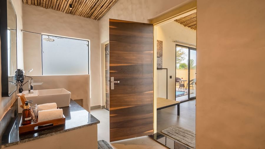 An image of a washroom featuring a sink and faucet, a tray where towels and body wash are kept - Kurja Jawai