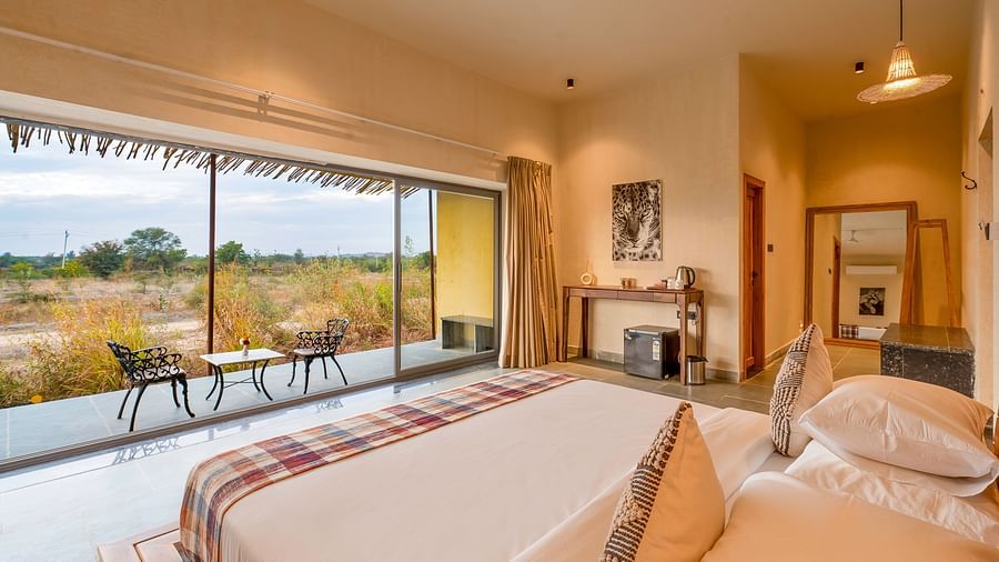 An image of bedroom featuring a double size bed, a table with tea and coffee maker, and a courtyard with seating area at Kurja Jawai