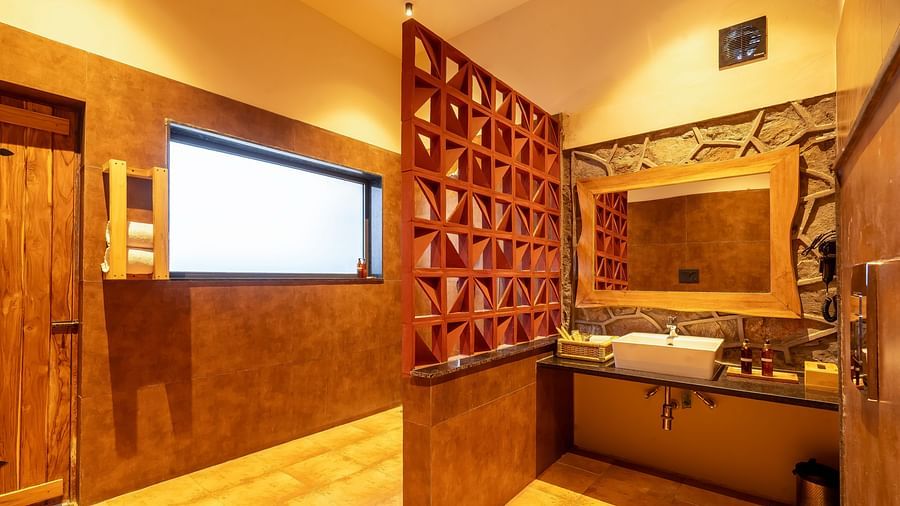 An image of a washroom featuring a mirror on the wall, sink and faucet and some trays where bodycare products are kept at Kurja Jawai