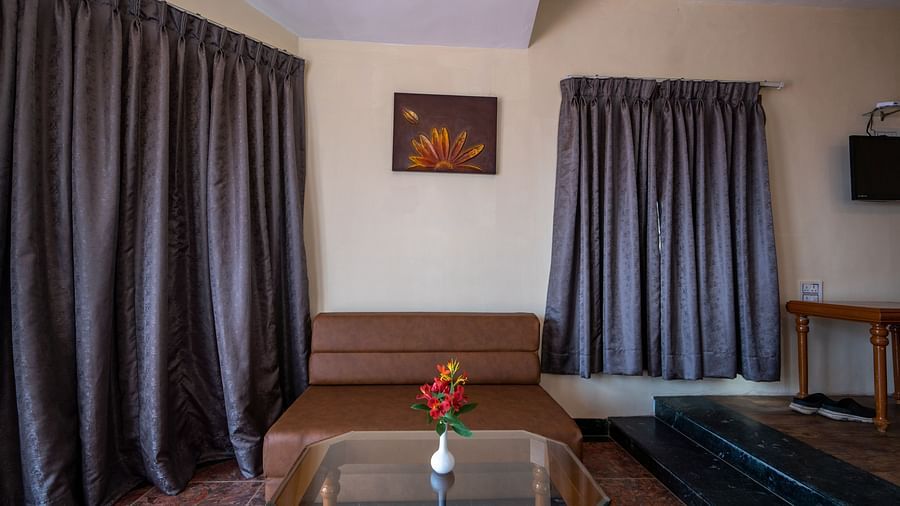 am image of a brown sofa and a picture hanging on the wall at La Montana By TGI, Ooty