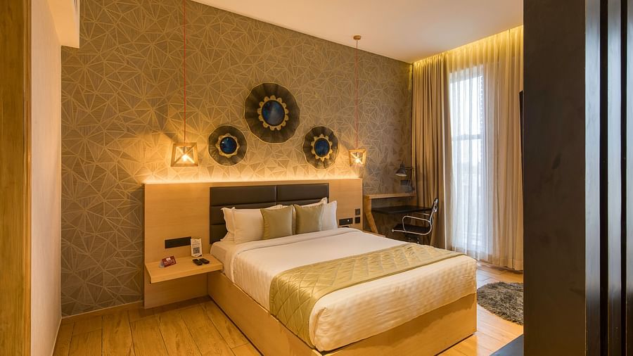 A double bed with golden bedsheets at Sumo Suite at Le Foliage by TGI, Bangalore