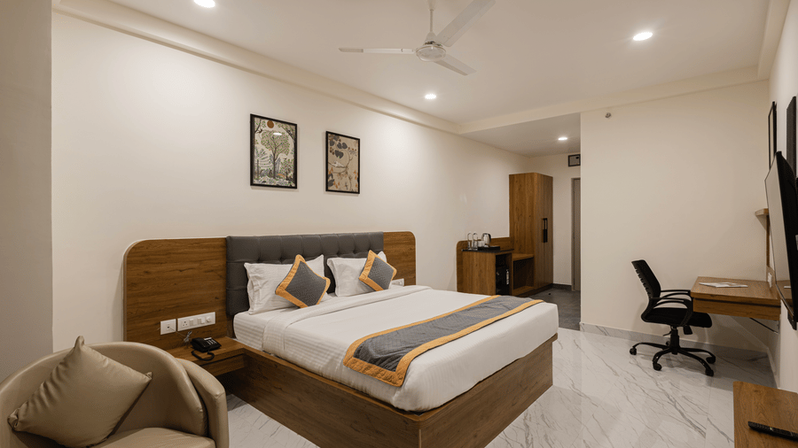 Well-furnished guest room with desk, chair, and king-size bed at Lemonridge Hotels, IDPL Balanagar.