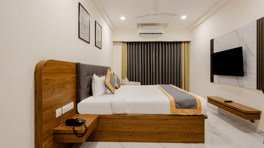 Clean, elegant cosy king room with mounted TV and minimal decor at Lemonridge Hotels, IDPL Balanagar