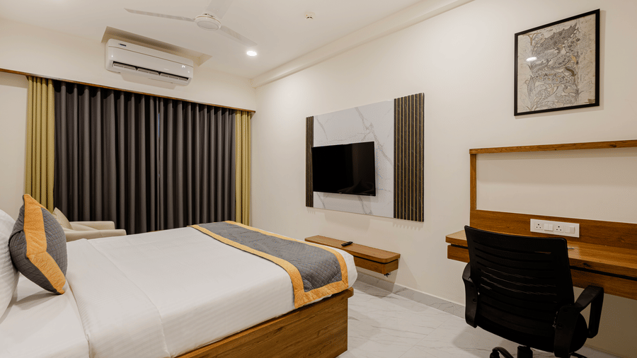 Well-lit cosy king room with king-size bed and wood-finish furniture at Lemonridge Hotels, IDPL Balanagar