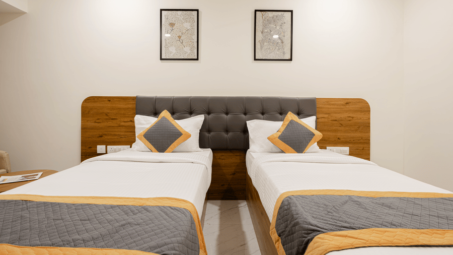 Comfortable twin-bed setup with minimal decor at Lemonridge Hotels, IDPL Balanagar