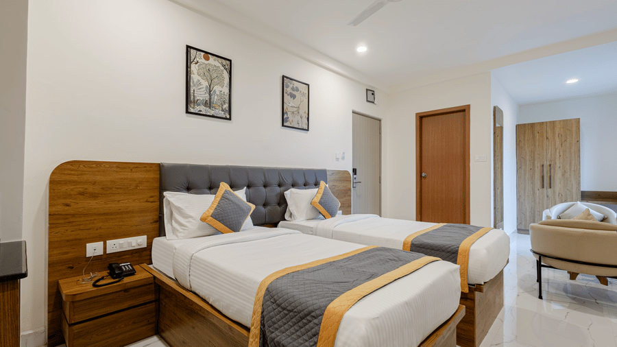 Neatly arranged double bed and workstation in a guest room at Lemonridge Hotels, IDPL Balanagar.