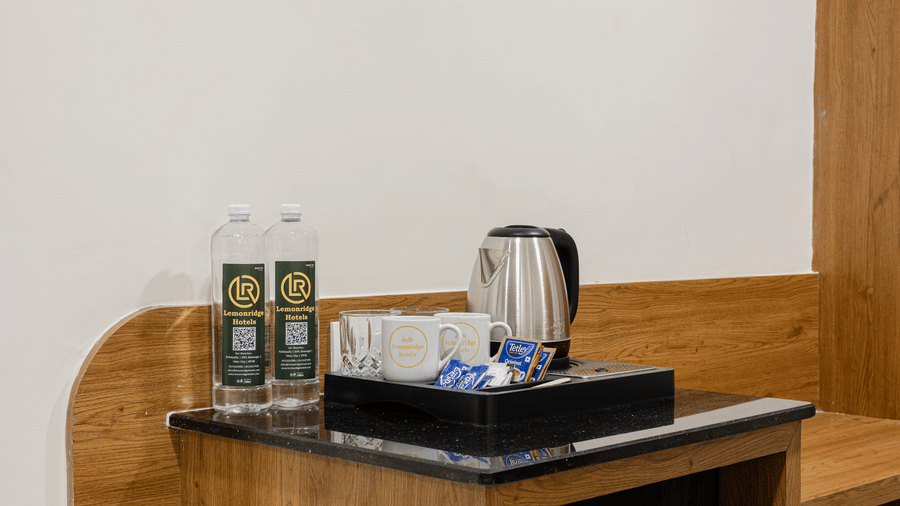 In-room tea and coffee setup with bottled water at Lemonridge Hotels, IDPL Balanagar.