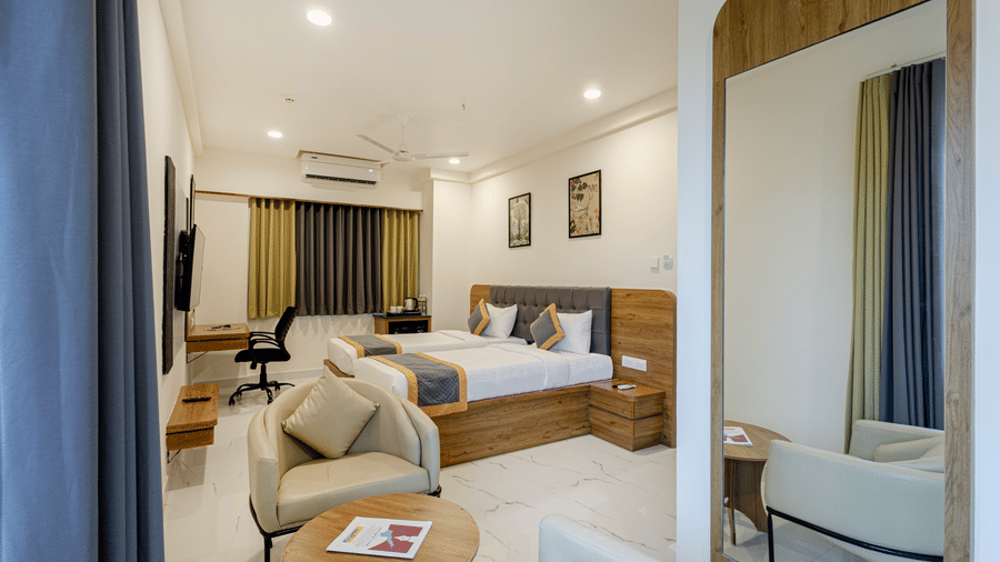 Stylish comfort twin room with soft lighting, seating area, and large bed at Lemonridge Hotels, IDPL Balanagar.