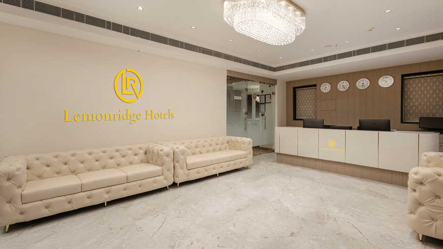 Reception lounge with white sofas and Lemonridge Hotels logo at IDPL Balanagar.