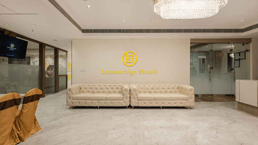 Spacious hotel lobby with chandeliers and Lemonridge branding at IDPL Balanagar.