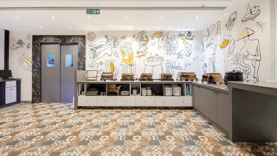 Restaurant reception area with artistic wall mural at Lemonridge Hotels, IDPL Balanagar