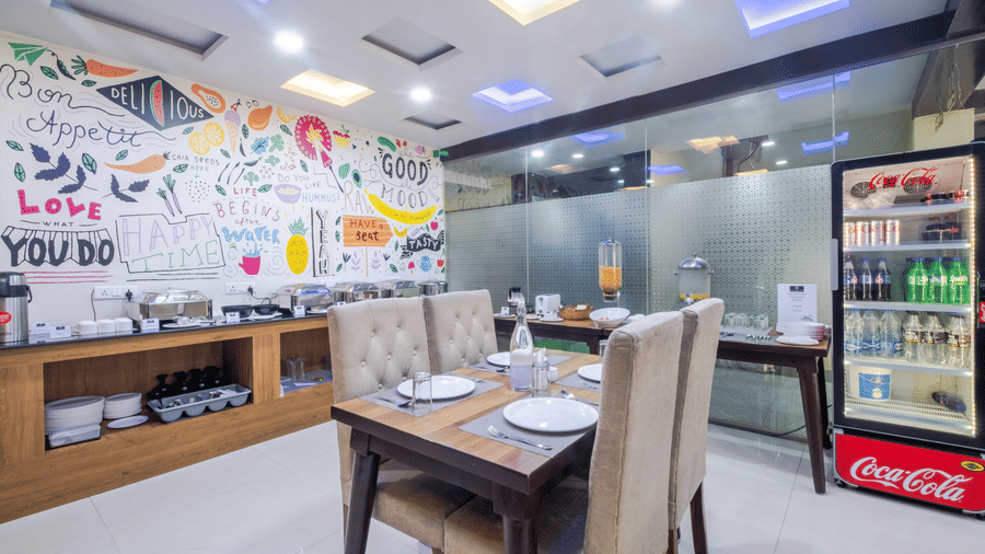 Restaurant featuring artistic wall decor, small dining table and beverage cooler at Lemonridge by Monday Hotels - Kukatpally.