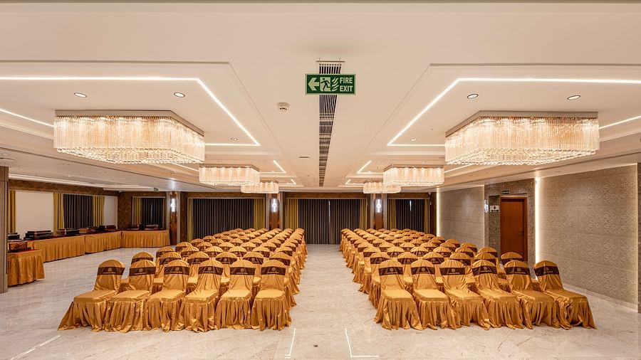 Banquet hall setup with golden chairs and chandeliers at Lemonridge Hotels, IDPL Balanagar.