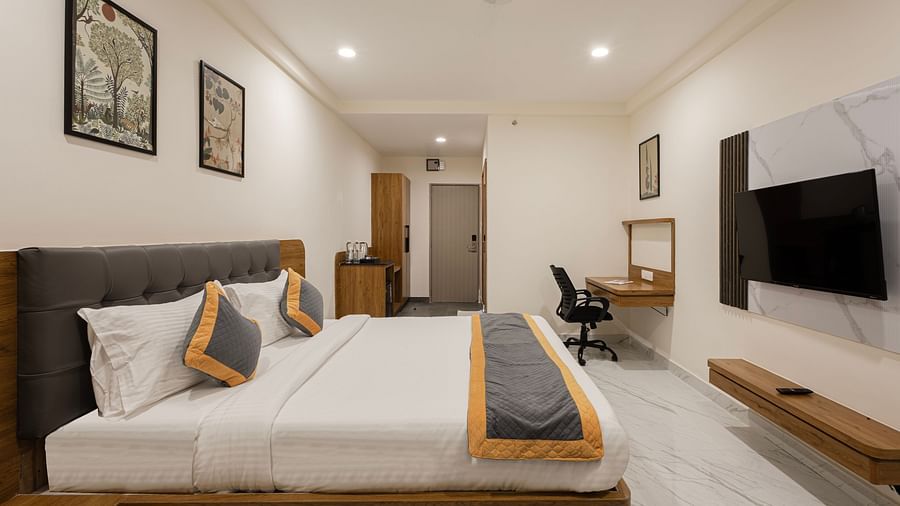 Elegant room with wall-mounted TV, work desk, and twin bedding at Lemonridge Hotels, IDPL Balanagar.