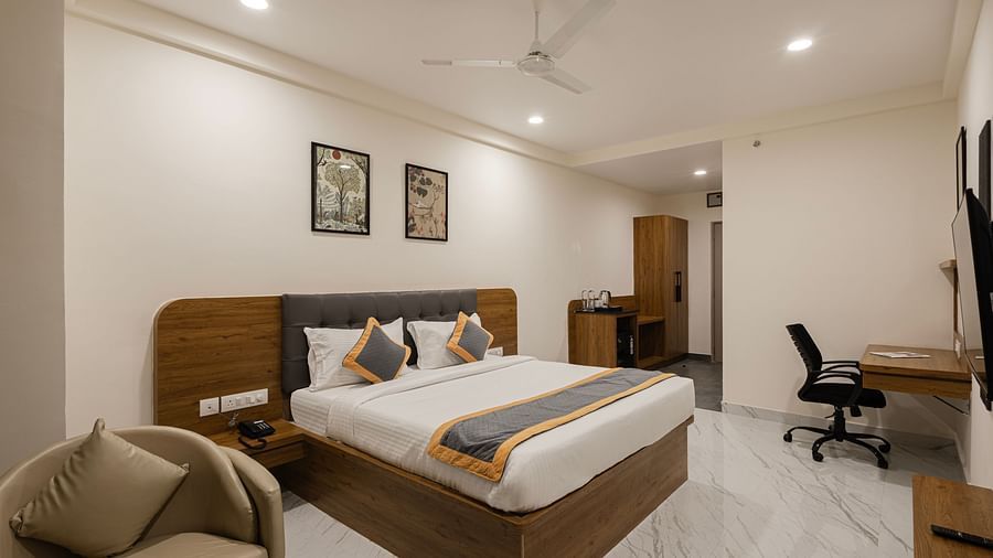 Well-furnished guest room with desk, chair, and king-size bed at Lemonridge Hotels, IDPL Balanagar.