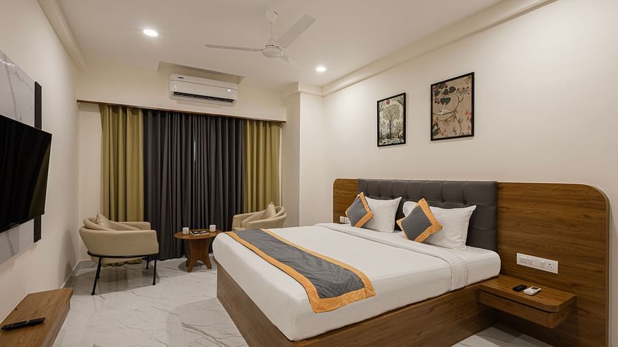 Comfortable room with bright curtains, bed, and wall art at Lemonridge Hotels, IDPL Balanagar.
