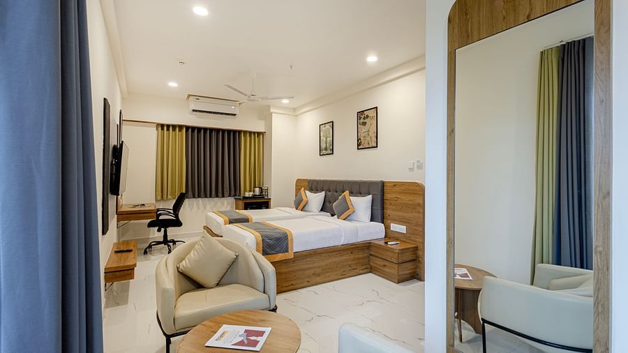 Stylish comfort twin room with soft lighting, seating area, and large bed at Lemonridge Hotels, IDPL Balanagar.