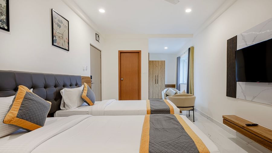 Twin-bed layout with wooden furnishings and corridor view at Lemonridge Hotels, IDPL Balanagar.
