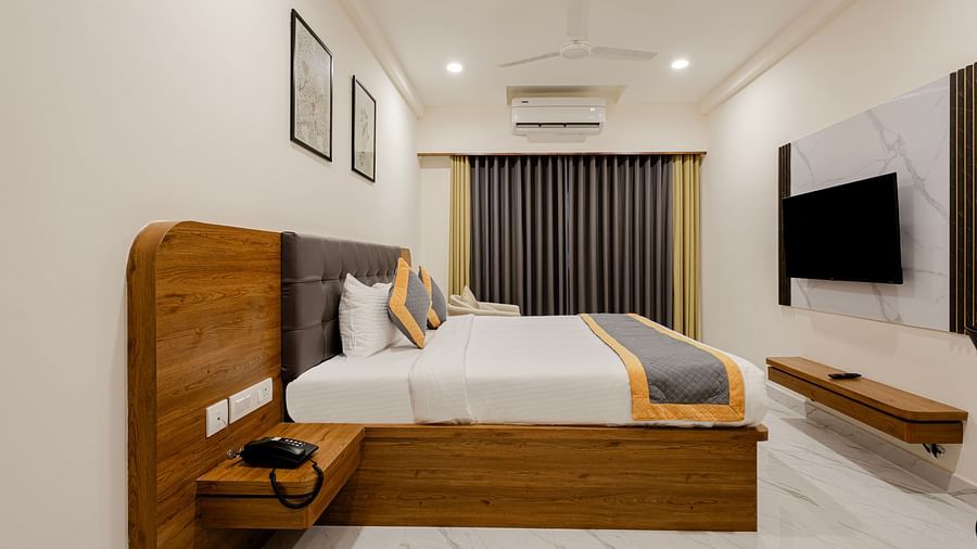 Clean, elegant cosy king room with mounted TV and minimal decor at Lemonridge Hotels, IDPL Balanagar