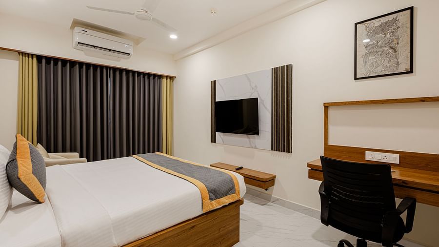 Well-lit cosy king room with king-size bed and wood-finish furniture at Lemonridge Hotels, IDPL Balanagar
