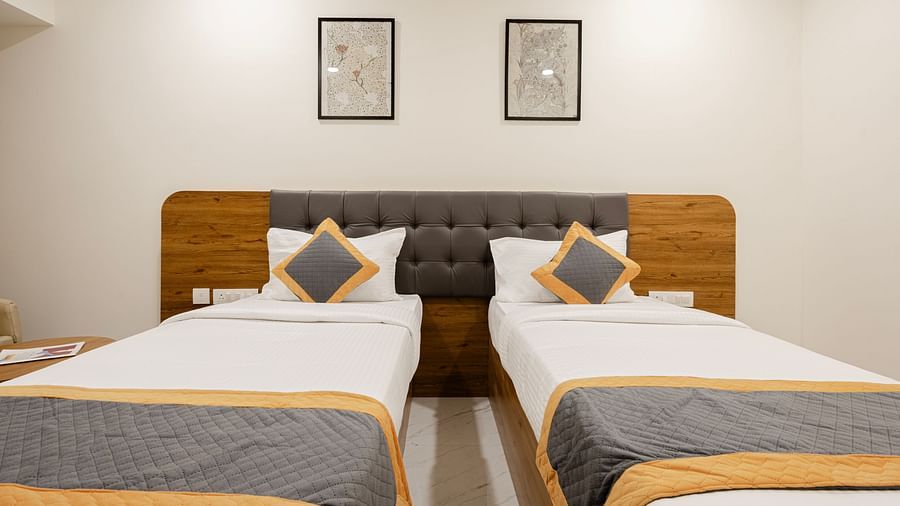 Comfortable twin-bed setup with minimal decor at Lemonridge Hotels, IDPL Balanagar