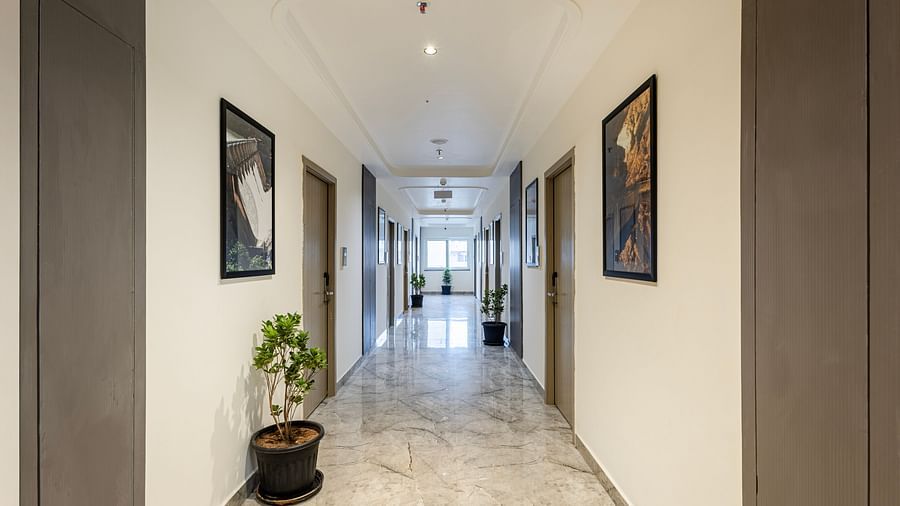 Bright corridor with marble flooring and framed artwork at Lemonridge Hotels, IDPL Balanagar.