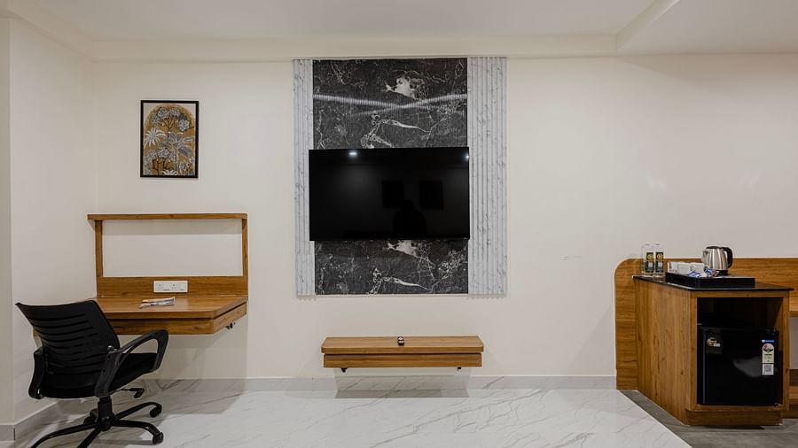 Premium room with flat screen TV, writing desk, and seating area at Lemonridge Hotels, IDPL Balanagar.