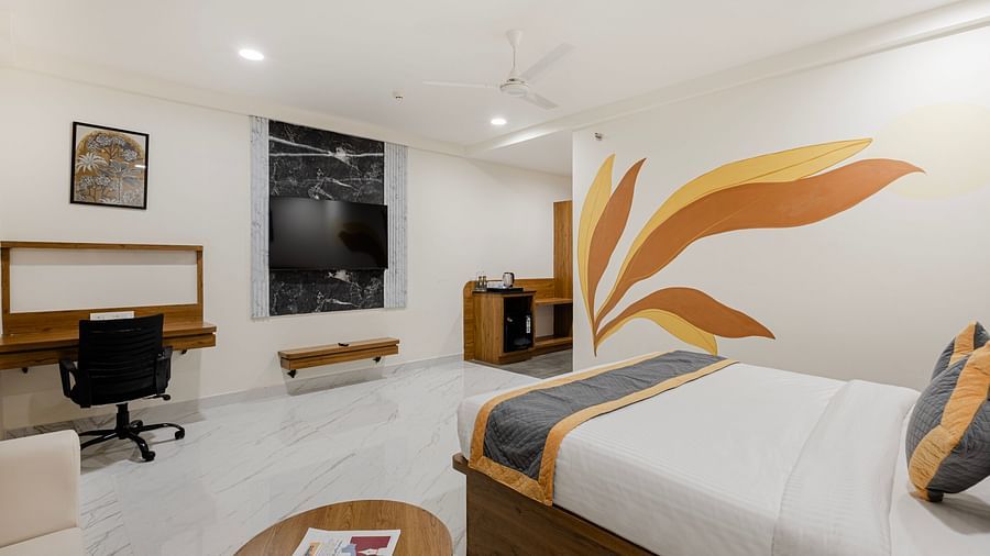 Room with decorative mural, work desk, and king-size bed at Lemonridge Hotels, IDPL Balanagar.