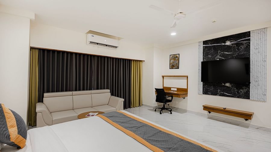 Interior view of bedroom featuring work desk and window curtains at Lemonridge Hotels, IDPL Balanagar.