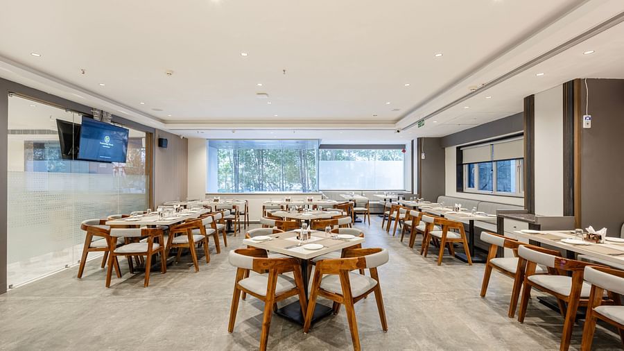Well-lit restaurant interior showcasing group dining tables at Lemonridge Hotels, IDPL Balanagar.