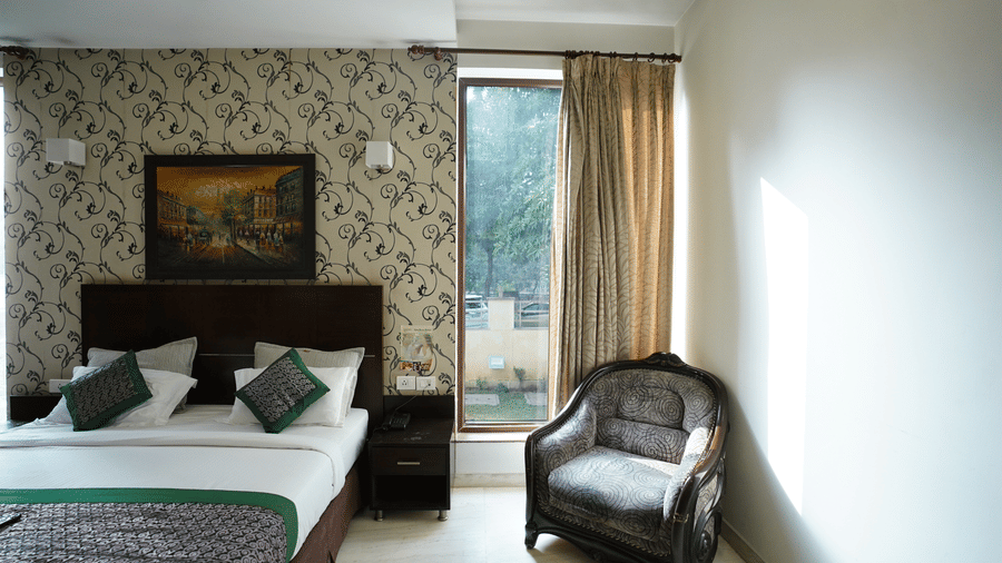 Double bed with fresh linens, a cosy armchair, elegant décor and a balcony bringing natural light into the room.