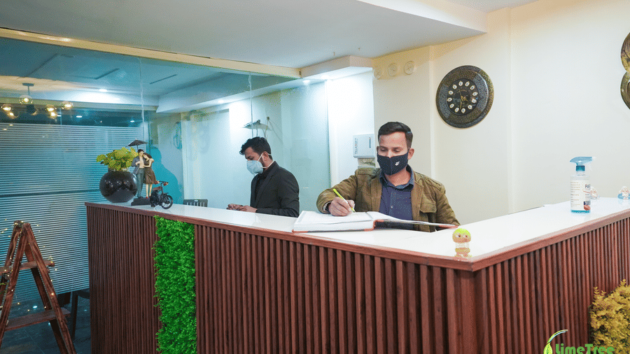 Staff members at the reception counter of Lime Tree Hotels & Service Apartment Private Limited.