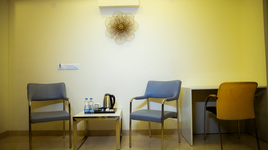 Seating area of Lime Tree Luxury Studio featuring armchairs, a table, a desk, and wall decor.