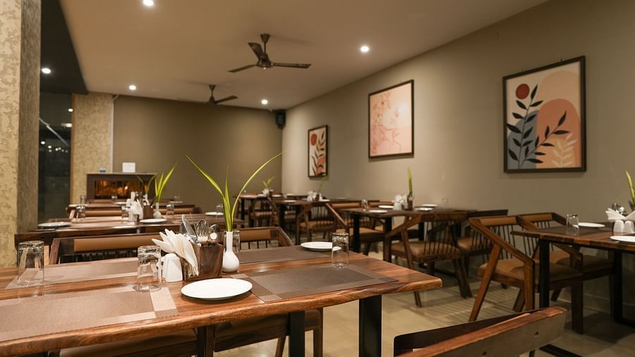 A restaurant view with ceiling fans, spotlights, and wooden dining furniture at TGI Livancia Hillside, JC Nagar, Mysore