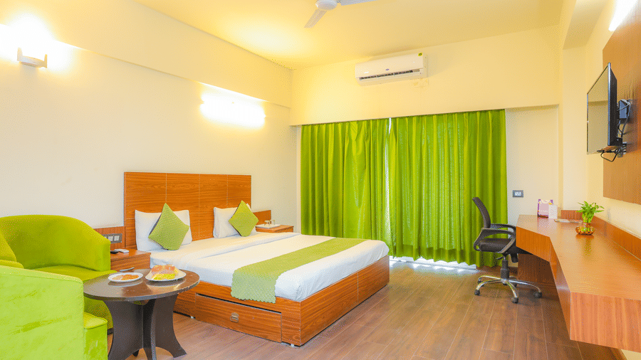 Wide view of the Suite With Balcony at Livbox, Dehradun, featuring a king size bed, air-conditioning, TV, and work desk.