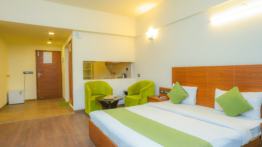 Side view of the Suite With Balcony showcasing the separate kitchen area which provides view of the king size bed  at Livbox, Dehradun.