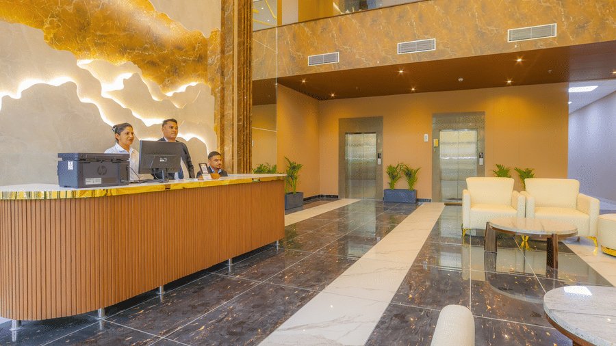3 people at the reception desk that is in the lobby of Livbox, Dehradun.