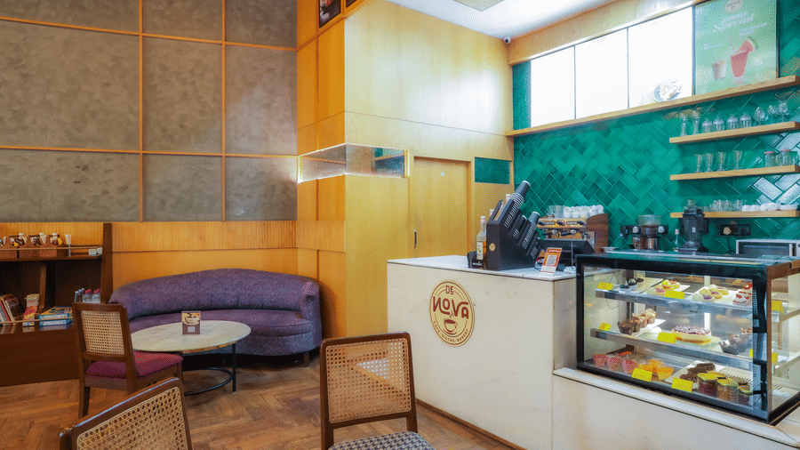 Cafe counter at Livbox Supernova, Noida, offering modern seating, colourful walls, and a display of beverages and treats.