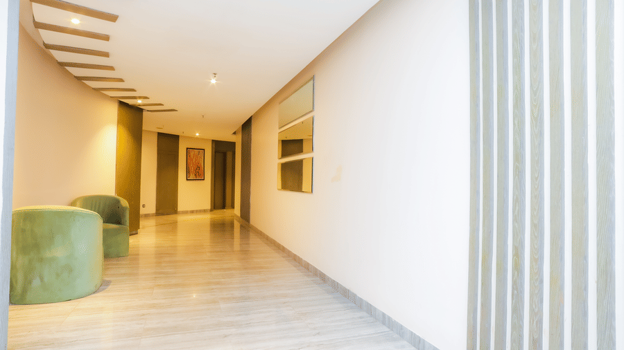 Bright, modern corridor with seating areas and curved ceiling design of Livbox Supernova, Noida.