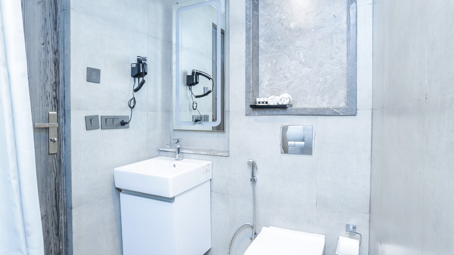 Modern bathroom with shower, sink, and mirror in Livbox Supernova, Noida.