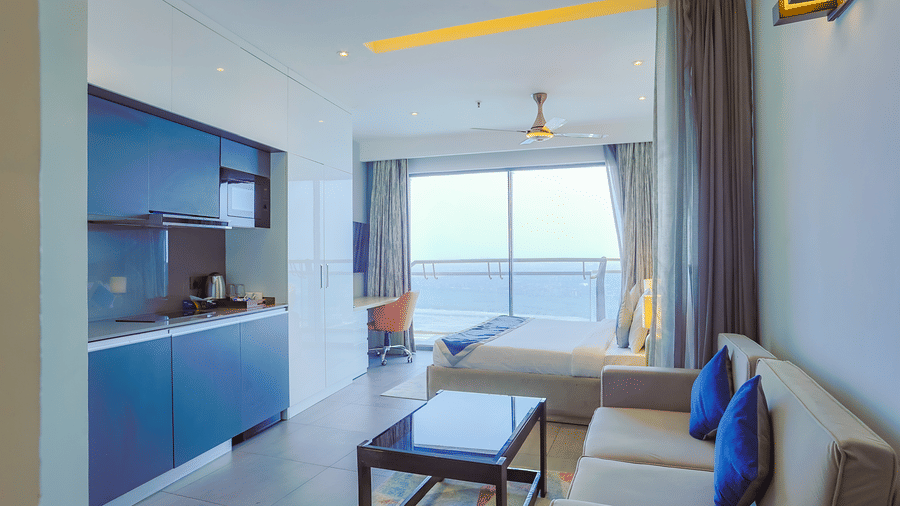 Spacious living area with sofa, table, and large window view in Livbox Supernova, Noida.