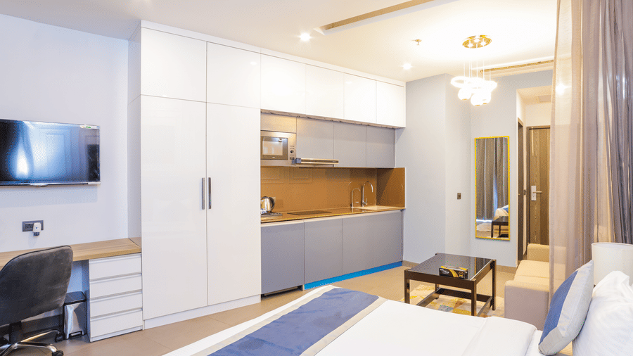 Stylish bedroom with a double bed, a wardrobe, and a TV at Livbox Supernova, Noida.