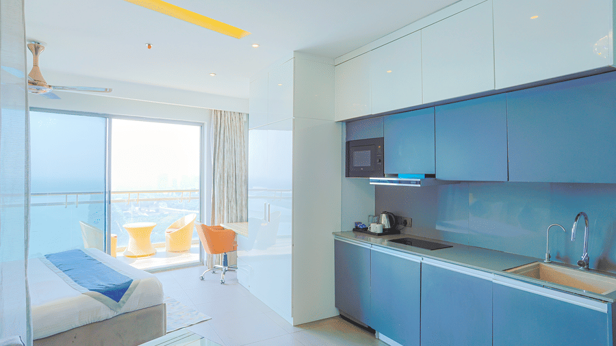 Modern kitchenette with spacious cabinets, sink, and large windows offering natural light at Livbox Supernova, Noida.