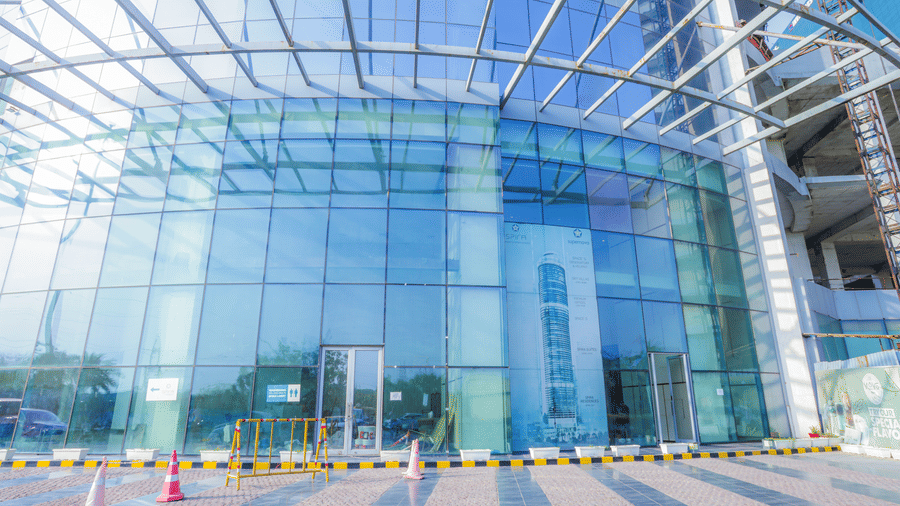 Modern glass-fronted commercial building of Livbox Supernova, Noida with a driveway and entrance canopy.