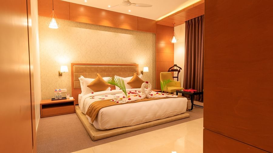A warmly lit hotel room at Lords Eco Inn Apple Gate features a decorated double bed and bedside tables.