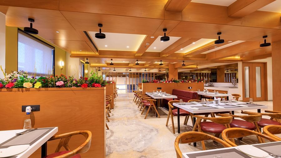 The brightly lit, spacious restaurant at Lords Eco Inn Apple Gate features numerous set tables and chairs, ready for diners.