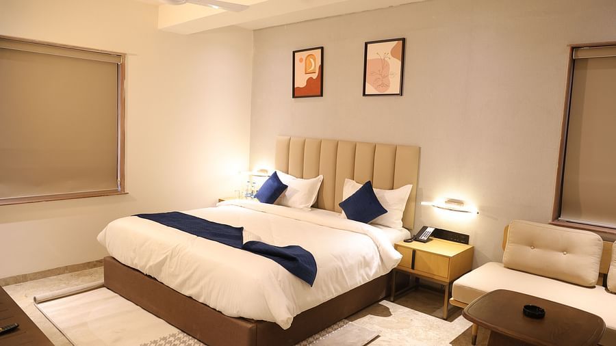 A luxurious Deluxe Room at Lords Eco inn Jamnagar Maheshwari Nagar showcasing a comfortable bed and contemporary furnishings.