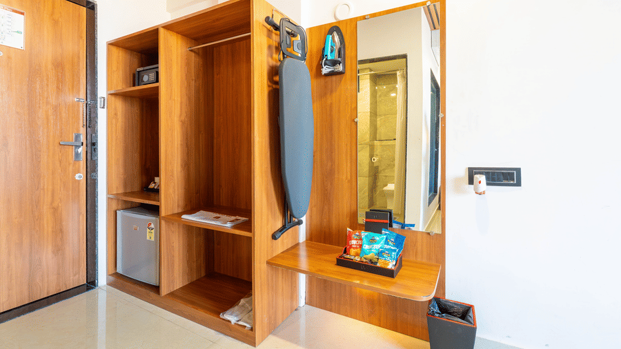 Open-concept wardrobe at Lords SKD Resort, Salangpur, equipped with an ironing board, mirror, and safe.
