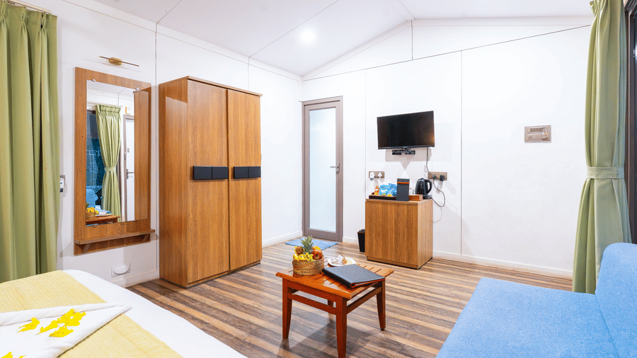 7Well-appointed room with bed, television, and seating area at Lords SKD Resort, Salangpur.